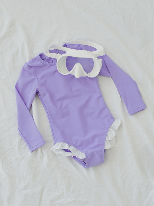 long sleeve lilac swimsuit with white ruffle and white scuba goggles